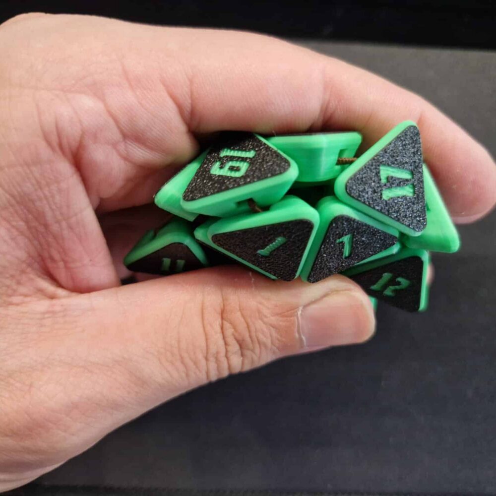 Hand drückt einen grünen Squishy D20 Fidget Würfel mit schwarzen Flächen und grünen Zahlen zusammen – zerdrückbarer Würfel für D&D und Tabletop.