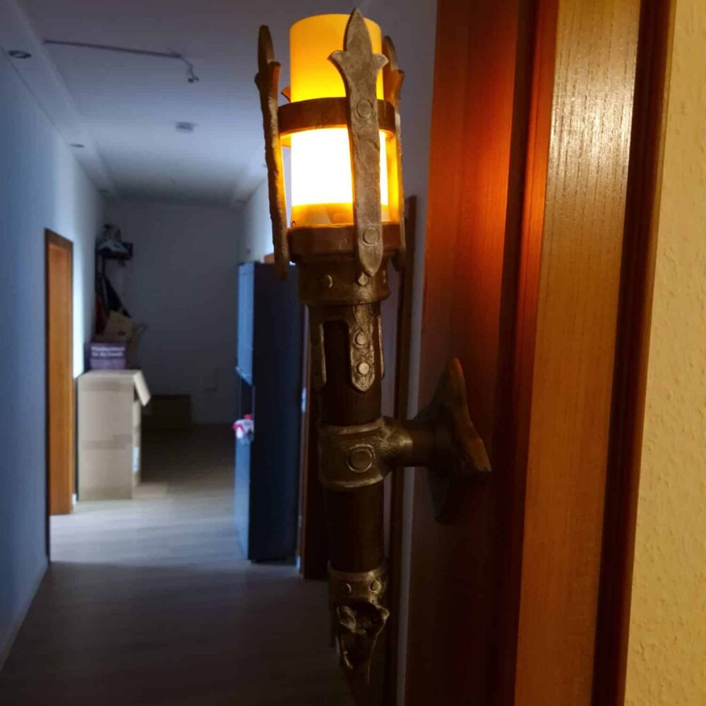 LED-Fackel an der Wand mit leuchtendem Flackerlicht, erzeugt warmes Dungeon- und Tavernengefühl. Ideal für Gaming- und Fantasy-Deko.