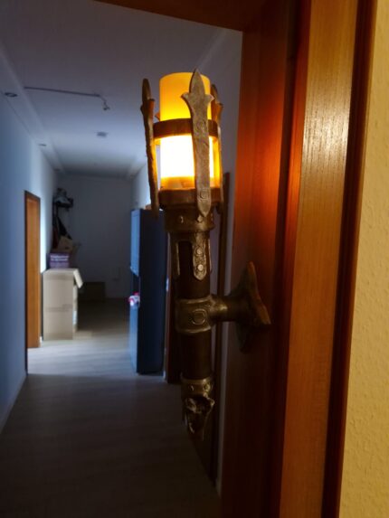 LED-Fackel an der Wand mit leuchtendem Flackerlicht, erzeugt warmes Dungeon- und Tavernengefühl. Ideal für Gaming- und Fantasy-Deko.