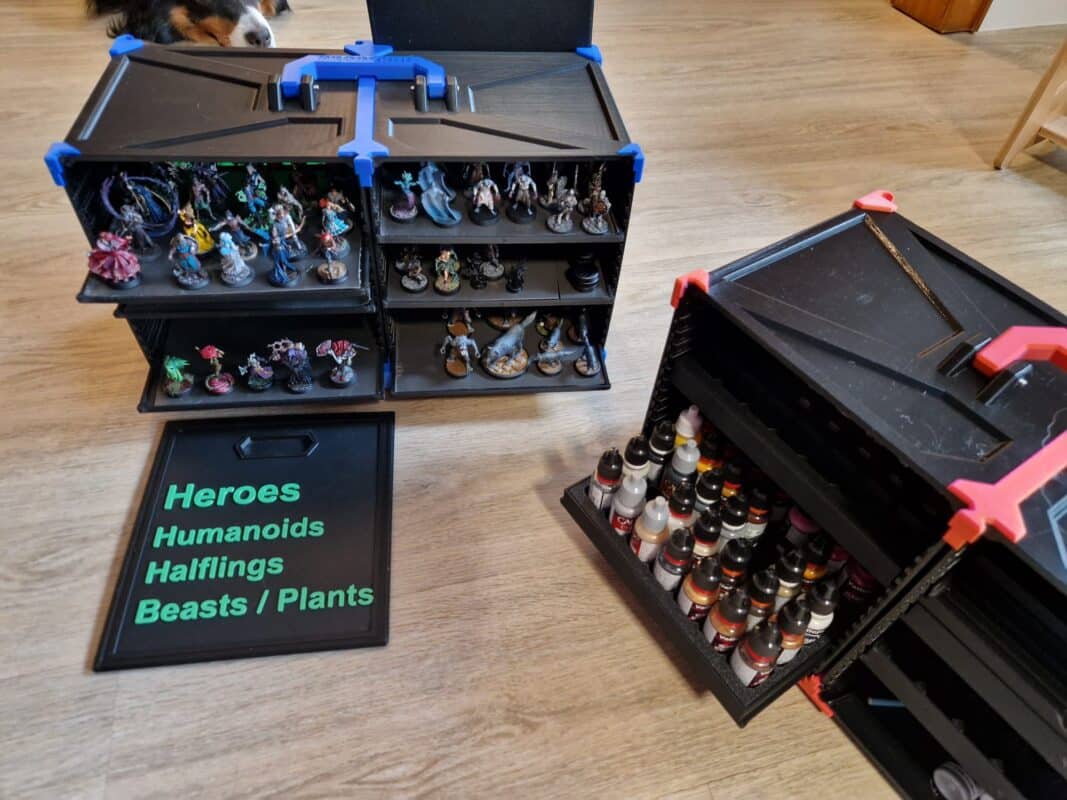 Aufbewahrungssystem für Tabletop-Miniaturen und Farben aus dem 3D-Druck. Links Regal mit handbemalten Figuren und Sortierplatten, rechts Farbständer für Citadel- und Vallejo-Farben. Praktische Organisation für Sammler und Hobbyisten.