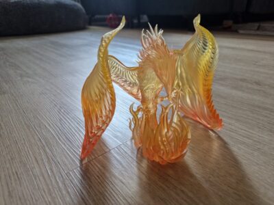 Detailreiche 3D-gedruckte Resin-Miniatur eines Phönix mit ausgebreiteten Flügeln. Transparentes Material in Orange-Gelb für realistische Flammenoptik. Ideal für Tabletop, Fantasy-Deko oder Sammler.