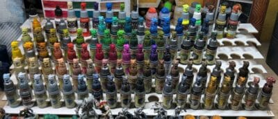Mehrreihiges Regal zur Aufbewahrung von Acrylfarben für Tabletop-Miniaturen. Gefüllt mit Vallejo- und Citadel-Farben in verschiedenen Farbtönen. Praktische Organisation für Mal- und Hobbyzubehör.